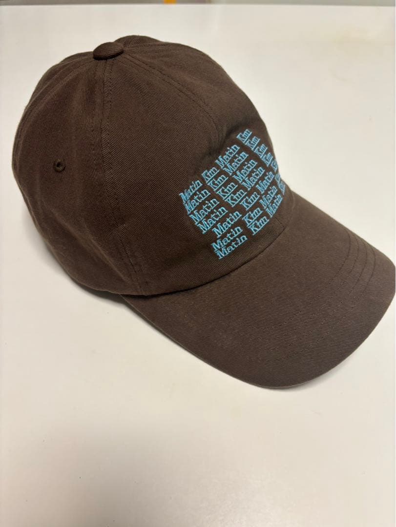 Matin Kim ブラウンキャップ 青色テキストプリント